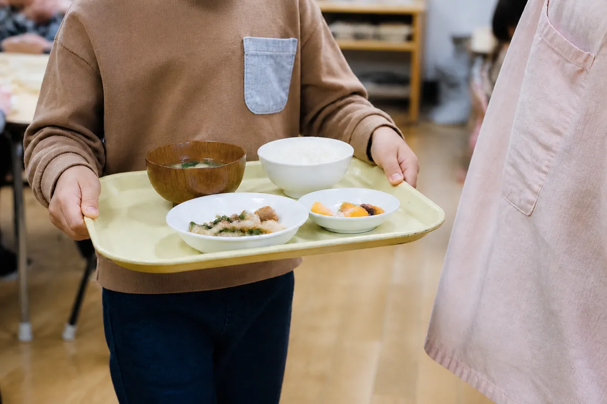 給食を運ぶ子どもの手