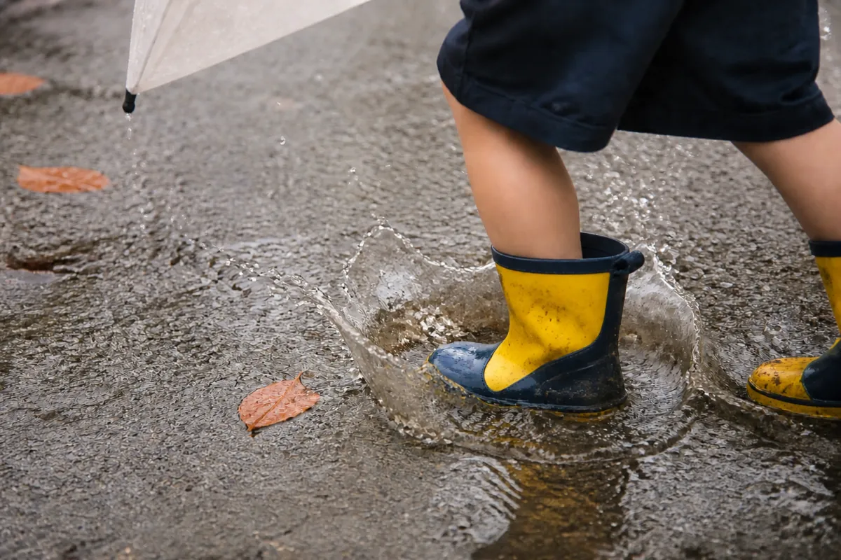 雨の日に水たまりで遊ぶ長靴